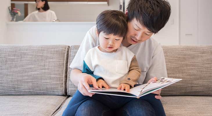幼児に絵本を読み聞かせている画像